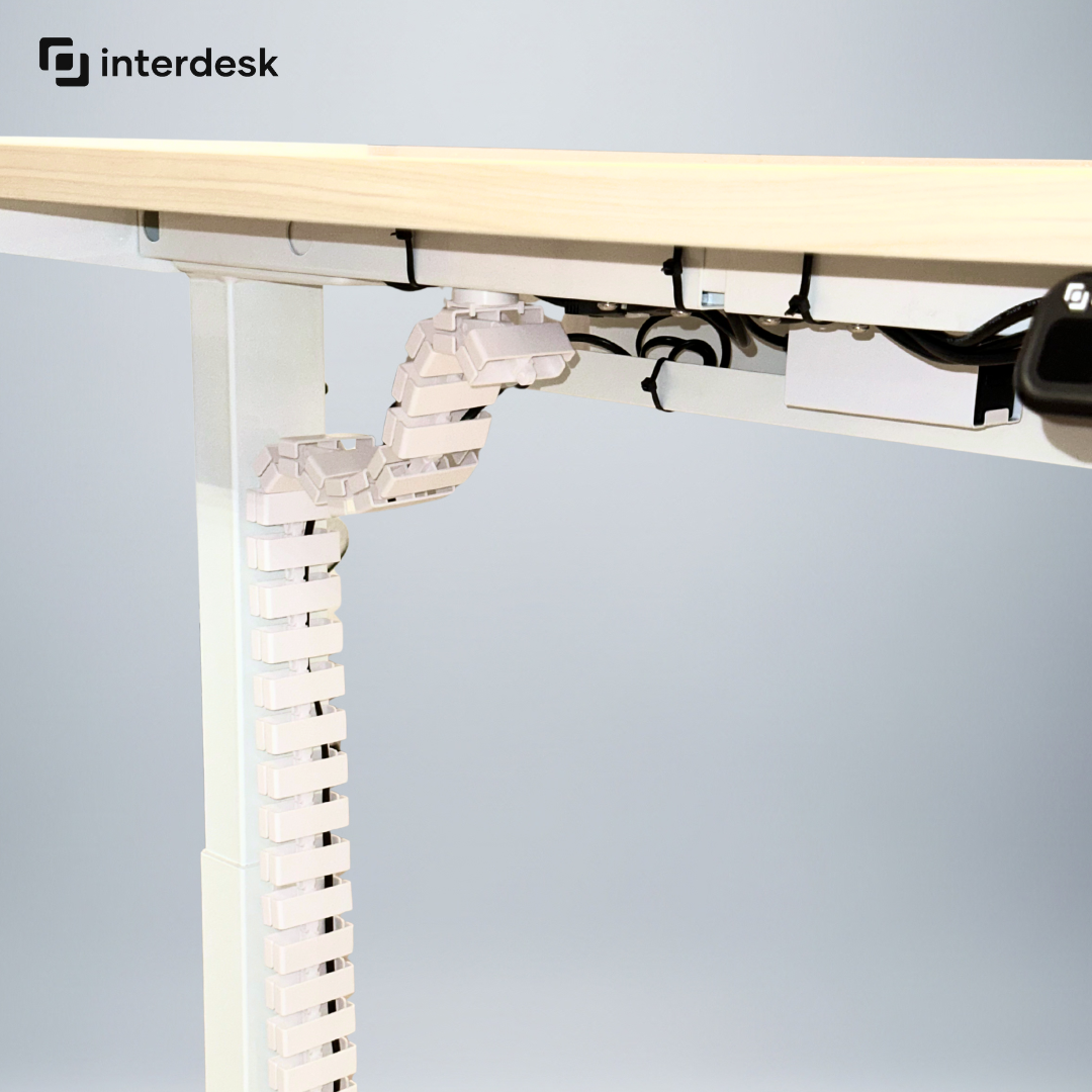 Under-desk cable management system with 'interdesk' branding on a light gray background